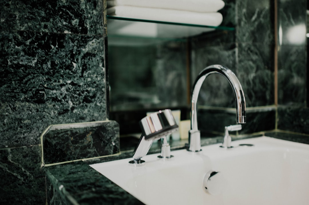 gray stainless steel faucet near mirror