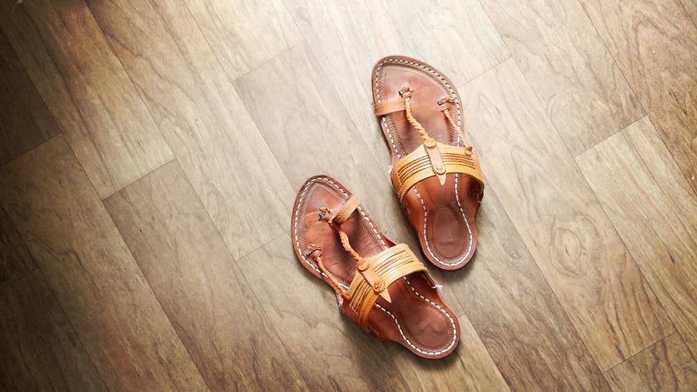 pair of brown T-strap sandals on floor