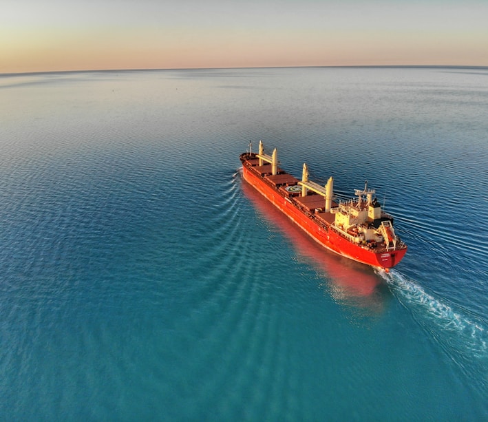 red and white cargo ship at middle of ocean