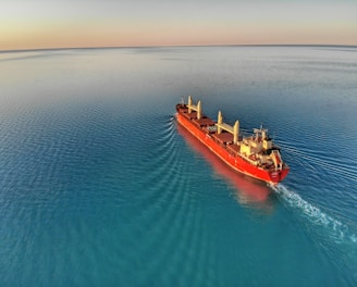 red and white cargo ship at middle of ocean