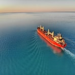 red and white cargo ship at middle of ocean