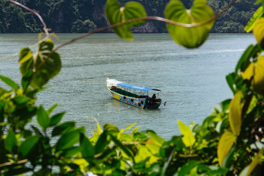 white and blue boat at middle of sea