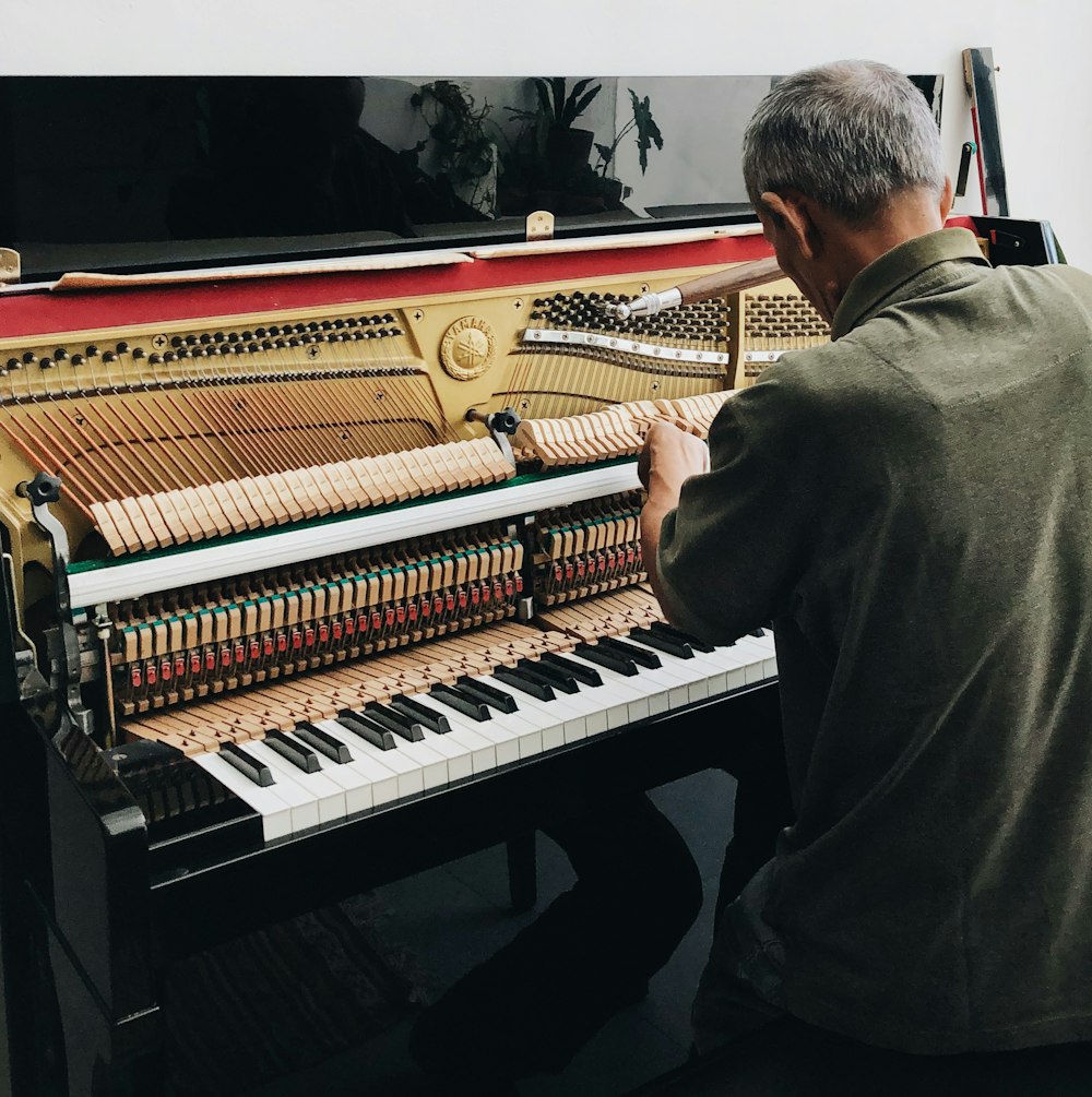 a man sitting at a piano playing a musical instrument