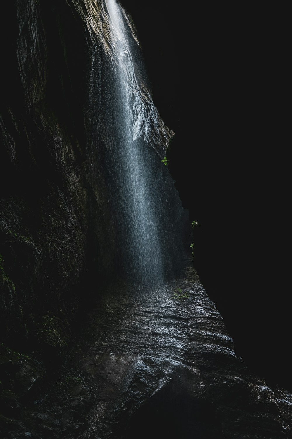 a waterfall in the middle of a dark cave