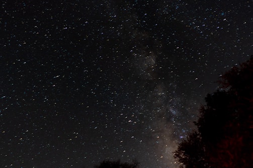 A stunning view of a starry night sky over a tranquil landscape.
