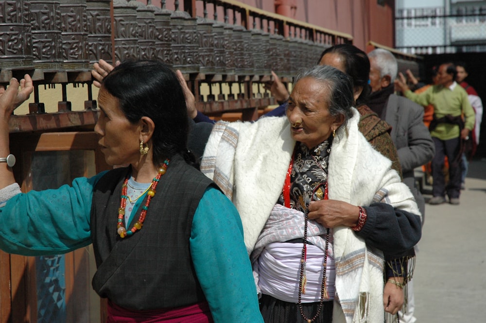 three women touching praying wheels