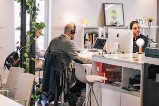 three men sitting on individual chairs inside room