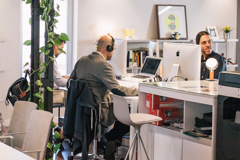 three men sitting on individual chairs inside room