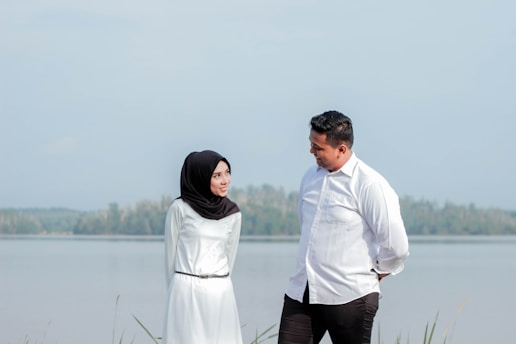 couple standing beside sea