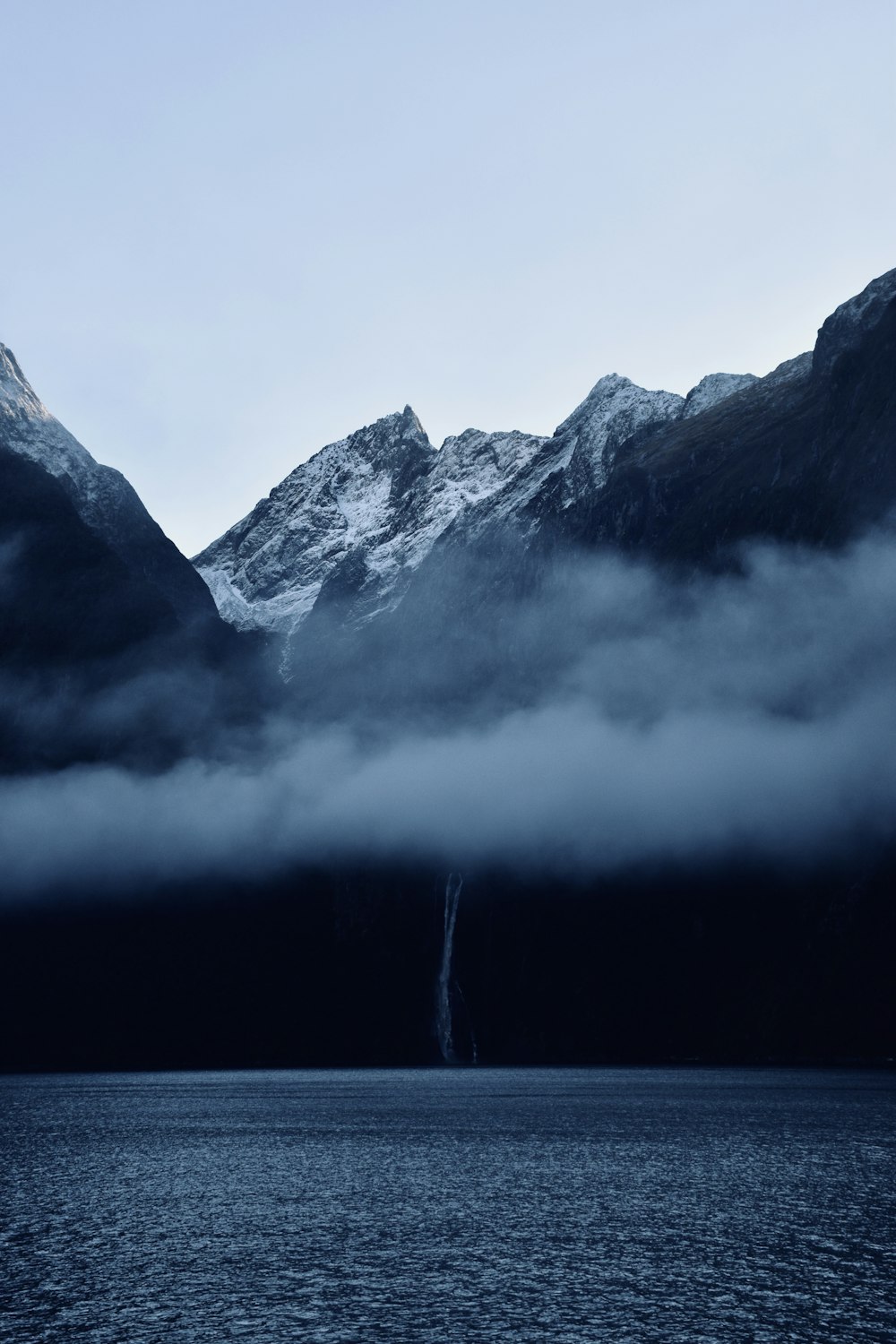 Montanha preta e branca perto do corpo de água