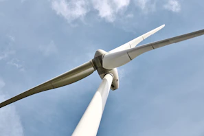 Close-up of wind turbine blades rotating gently against a clear blue sky.