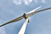 A close-up of wind turbine blades gracefully turning against a clear blue sky.