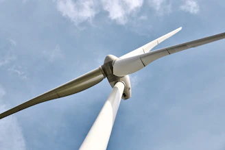 Close-up of modern wind turbine blades with a clear blue sky background.
