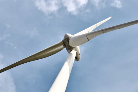 Close-up of modern wind turbine blades with a clear blue sky background.