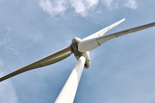A close-up of wind turbines spinning against a clear sky.