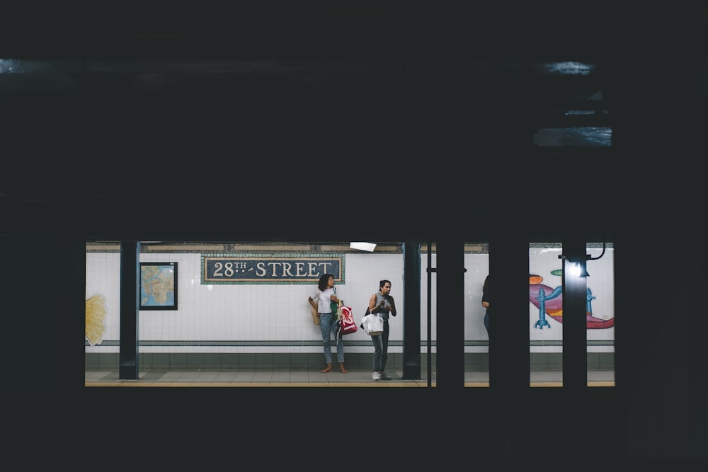 two women standing on train station