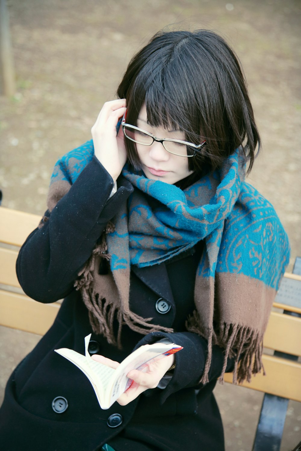 woman sitting on bench reading book