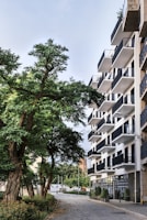 Modern townhouse featuring large windows and a cozy balcony overlooking tree-lined streets.