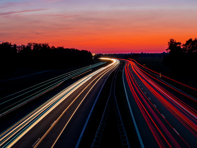 time-lapse photography of road under gray and orange sky