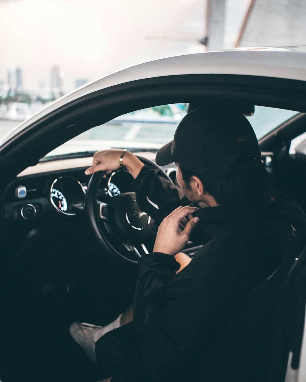 a person sitting in a car with a steering wheel