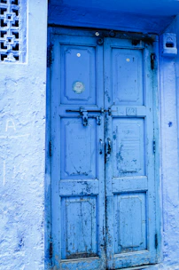A freshly painted door with crisp edges and rich, vibrant blue paint shining under soft light.