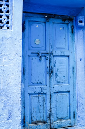 Before and after shots of a freshly painted front door in blue and silver tones.