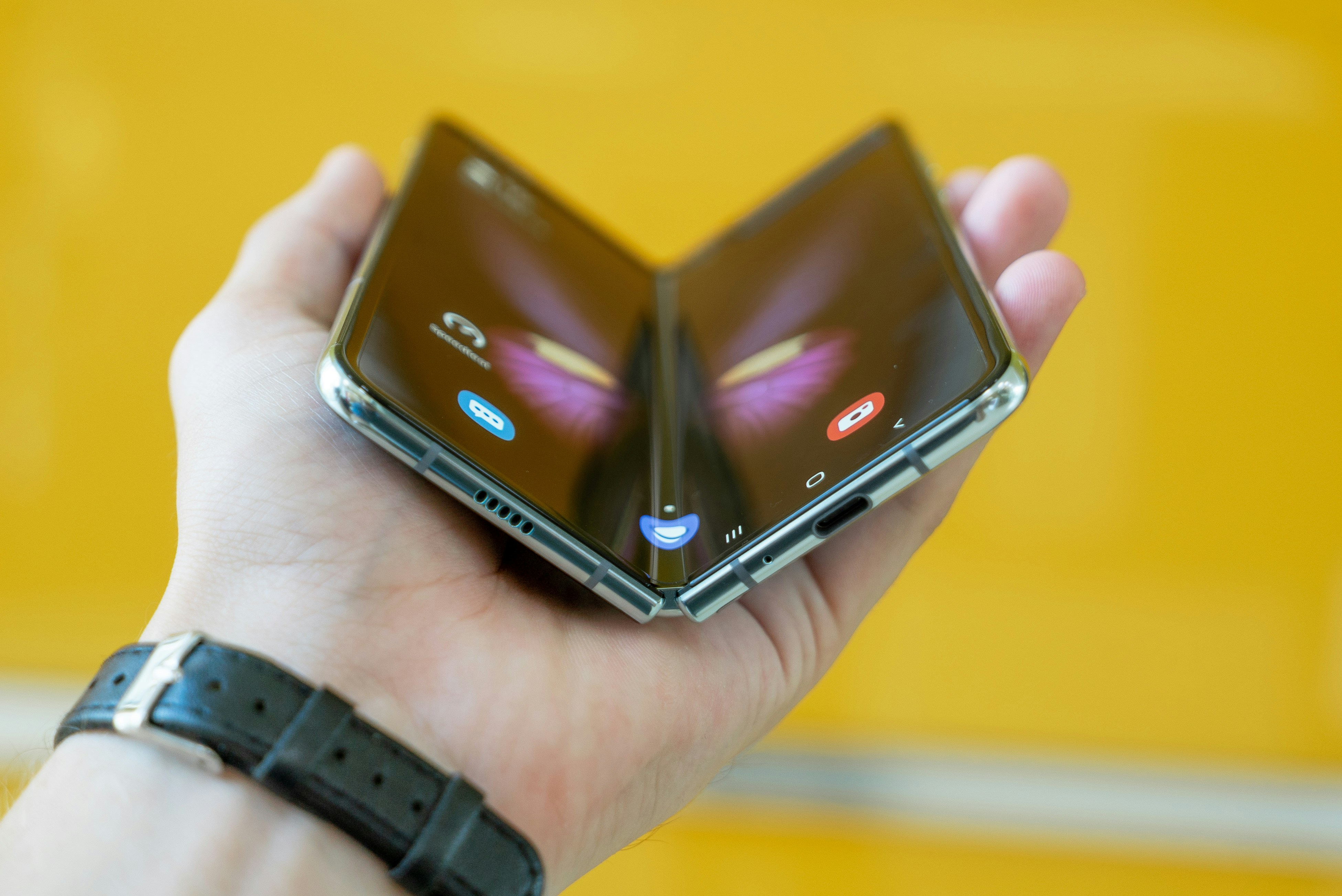 a book-style foldable smartphone captured mid-fold in a hand