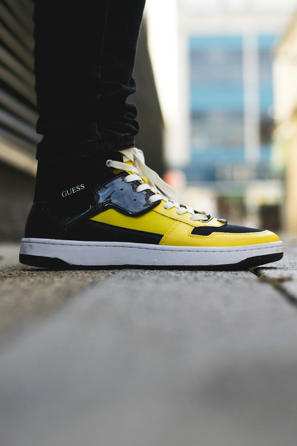 pair of yellow-and-black Guess high-top sneakers