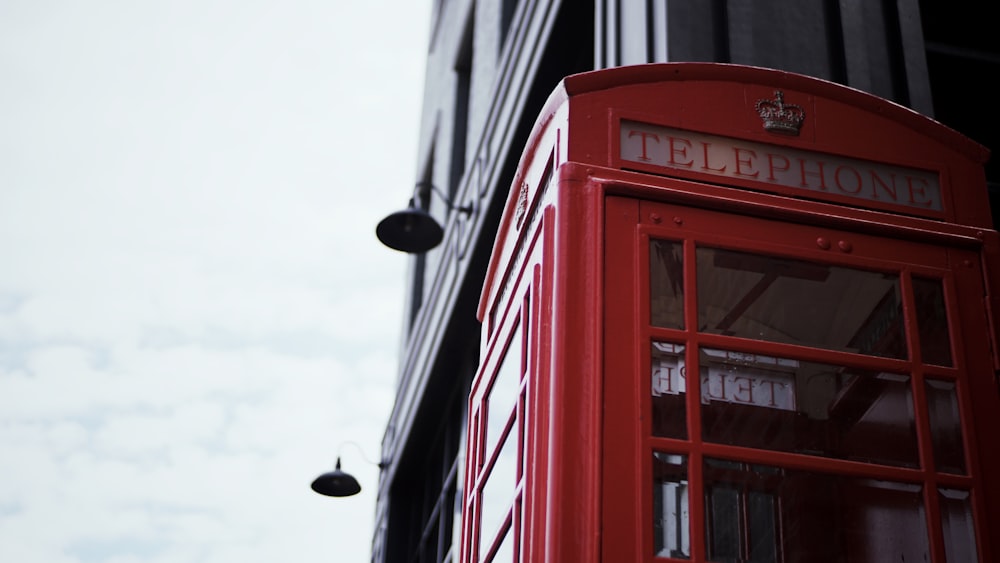 red telephone booth near building