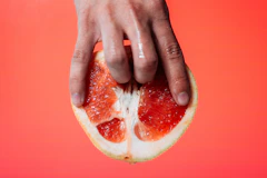 person holding red pomelo fruit