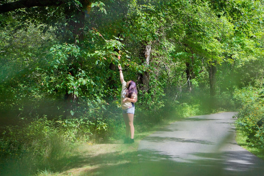 person standing near green-leafed trees during daytime