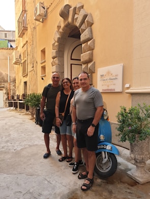A group photo of smiling participants outside a historic building in Faro, Portugal.