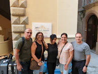 A family of pilgrims smiling together in front of a luxury hotel lobby.