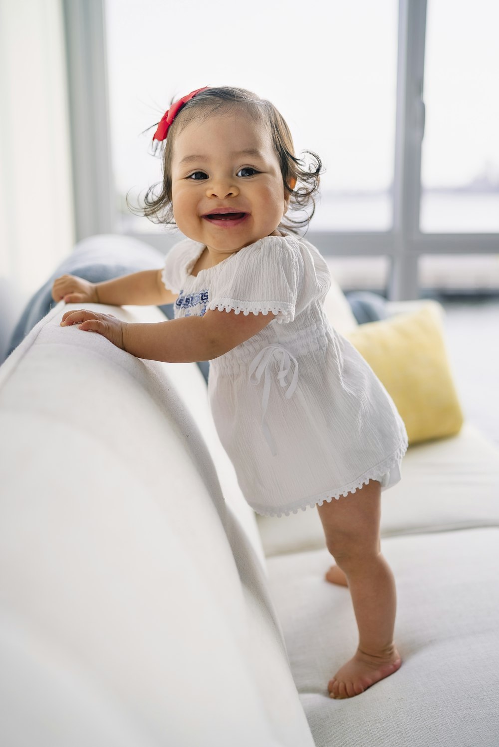 smiling toddler girl standing on sofa