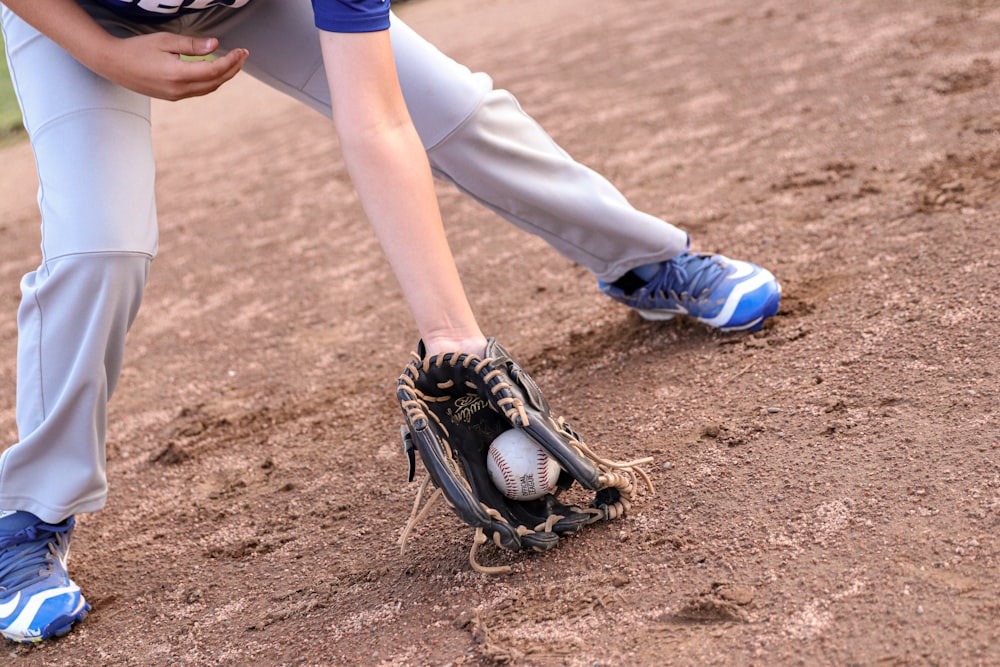 person wearing black leather baseball mitt catching baseball