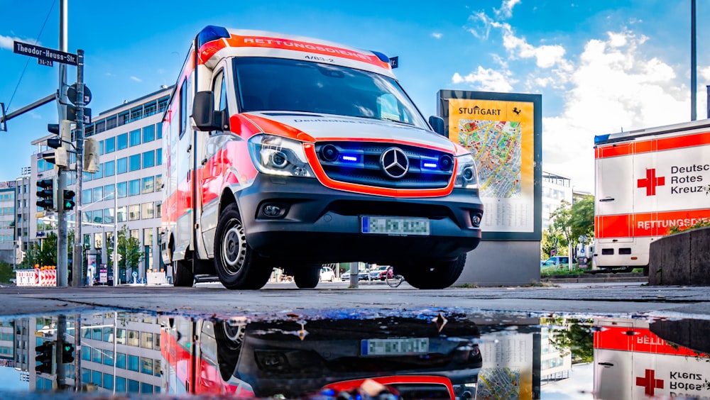 white and red Mercedes-Benz ambulace