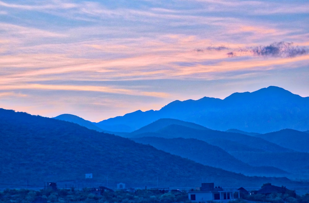 mountain range under orange and blue sky during golden hour