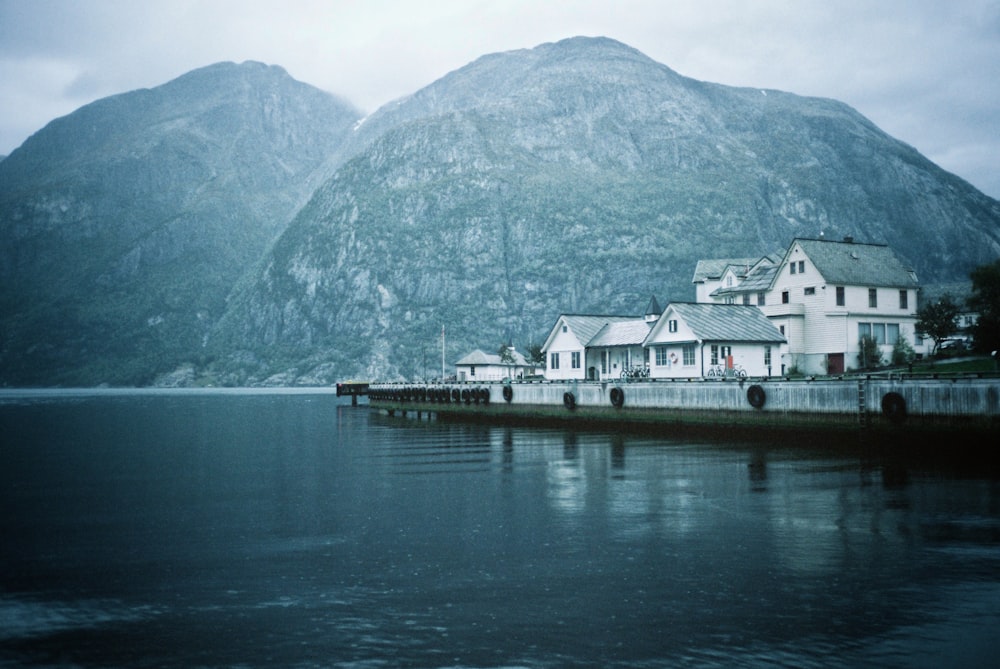 white concrete houses based calm water at daytime