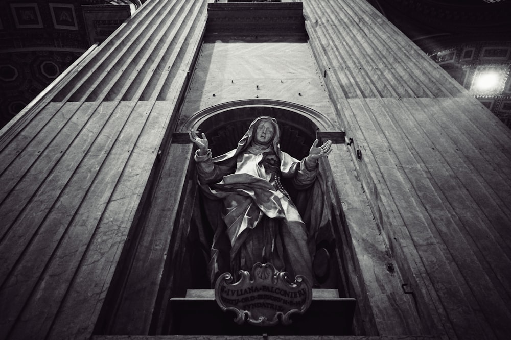 a statue of the virgin mary on the side of a building