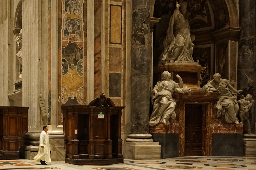 person in white suit standing inside church