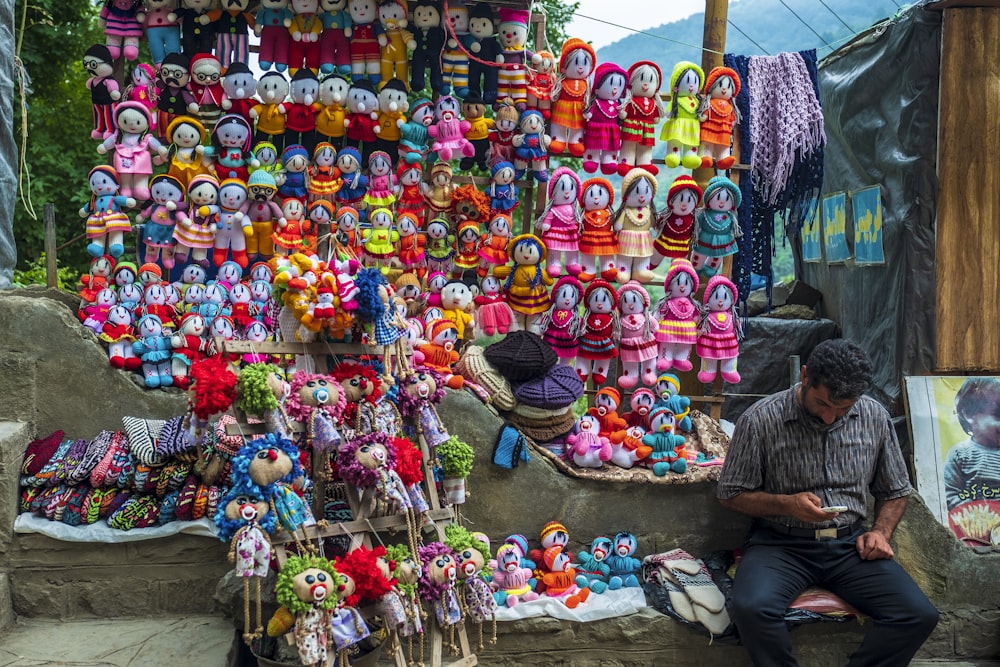 man sitting beside assorted-color display item