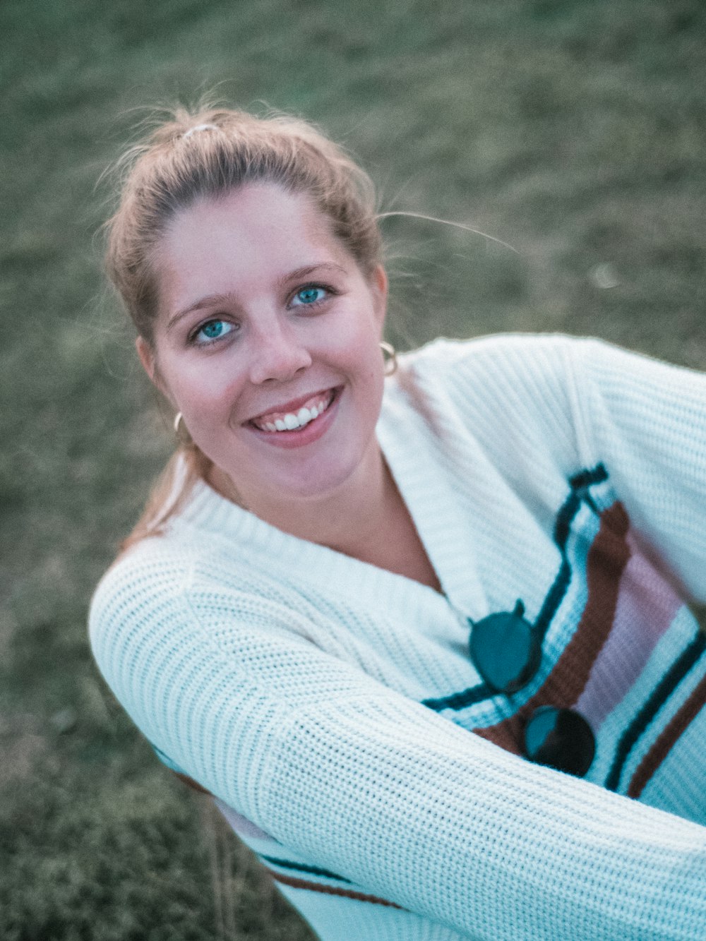 smiling woman wearing white V-neck sweater