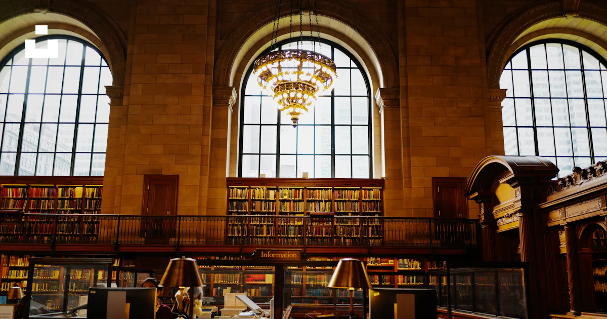 A library filled with lots of books and a chandelier photo – Free ...