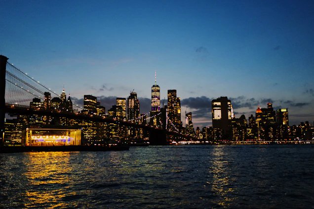 A cinematic shot of the New York City skyline at dusk with vibrant lights reflecting off glass buildings.