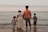 four people standing on seashore