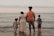 four people standing on seashore