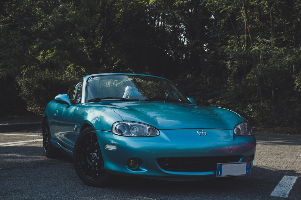 blue Mazda convertible coupe on road