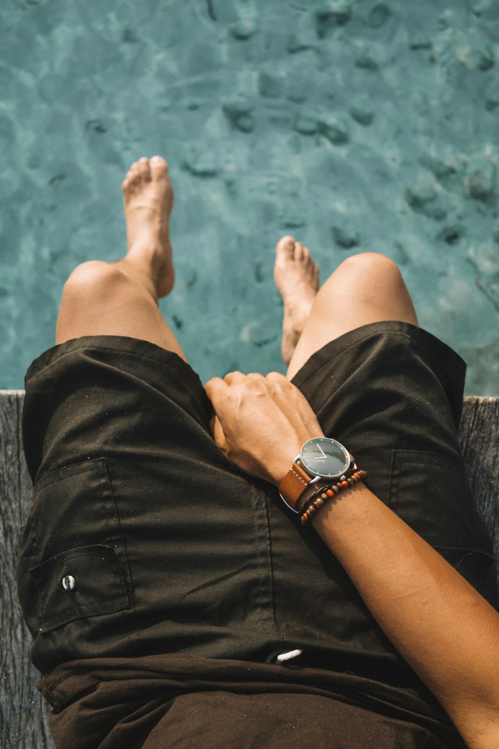 man sitting beside pool