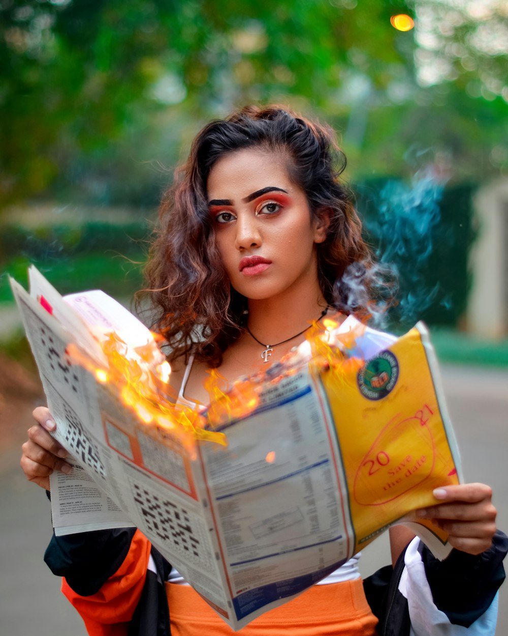 woman holding magazine while burning