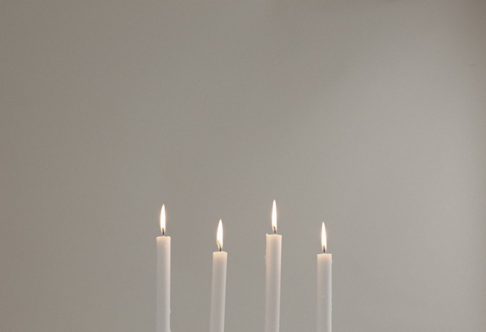 four lighted white candles